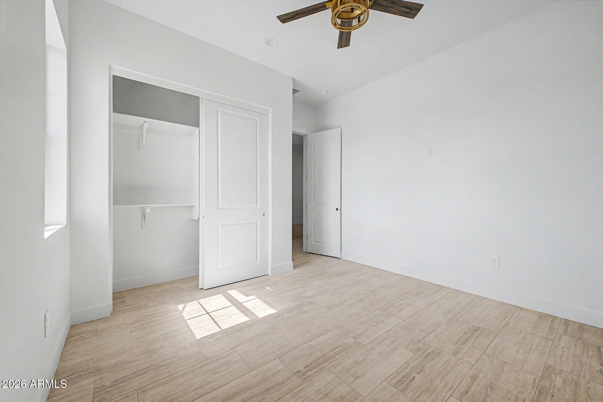 18815 West Arlington Road Buckeye, AZ 85326 - Photo 39 of 56 an empty room with wooden floor and windows
