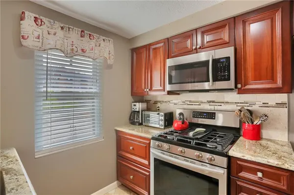 a kitchen with stainless steel appliances granite countertop a sink and a window