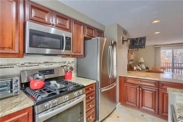 a kitchen with stainless steel appliances granite countertop a refrigerator sink and microwave
