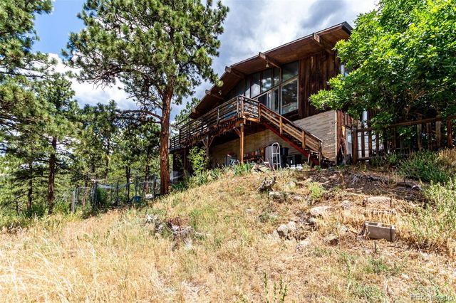 a view of a house with a yard and a large tree