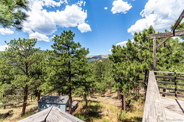 a view of a balcony with chairs and wooden umbrella