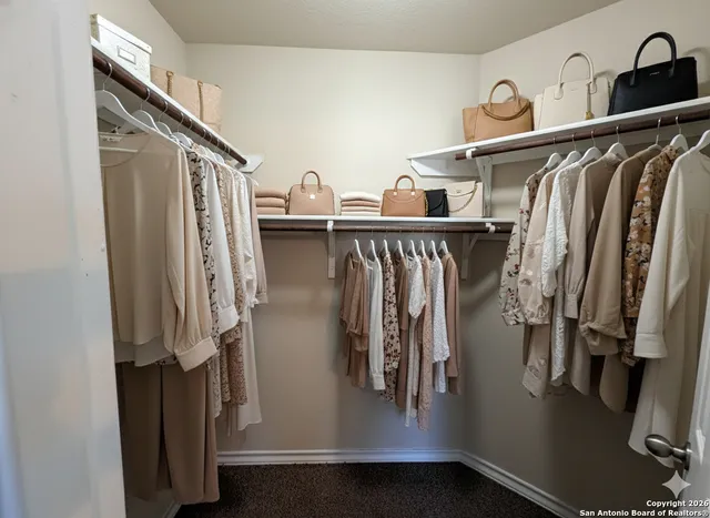 a view of walk in closet with clothes and shoes