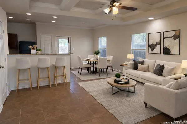 a living room with furniture a ceiling fan and a window