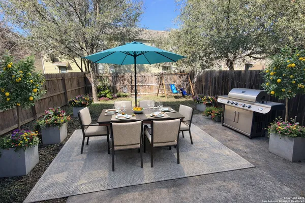 a view of backyard with wooden fence and large trees
