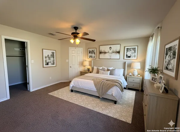 a bedroom with a large bed and a chandelier