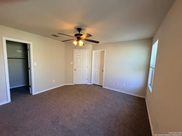 an empty room with a fan and a window