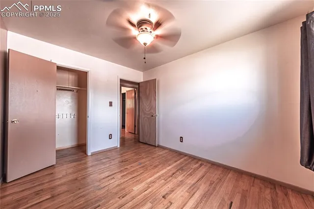 a view of an empty room with window and wooden floor