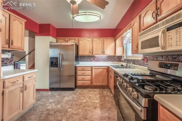a kitchen with stainless steel appliances granite countertop a stove refrigerator sink and cabinets