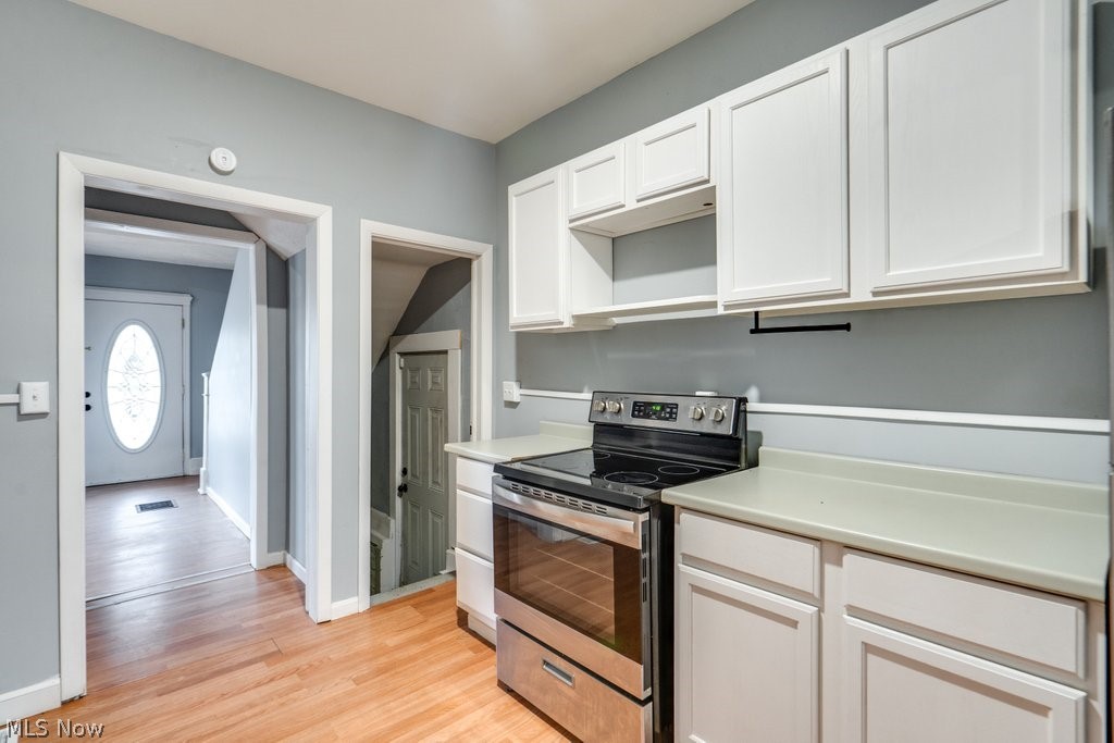 1607 9th Street Southwest Canton, OH 44706 - Photo 19 of 41 Kitchen featuring white shaker-style cabinetry, light-toned countertops, and a stainless steel electric range