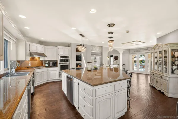 a large kitchen with stainless steel appliances lots of counter space and wooden floor