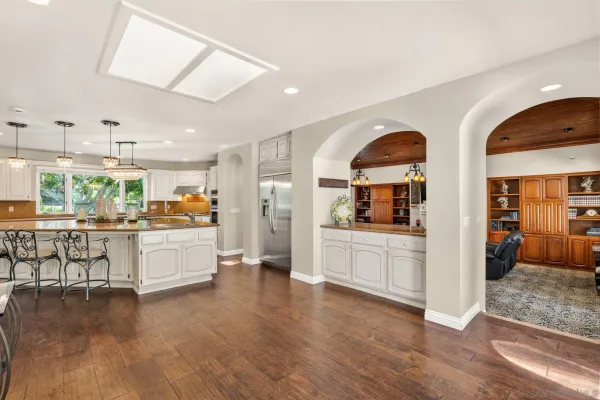 a large white kitchen with lots of counter space and stainless steel appliances