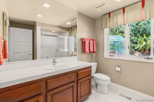 a bathroom with a sink a toilet and a window