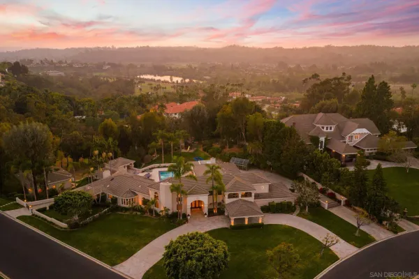 an aerial view of a house with a garden and lake view