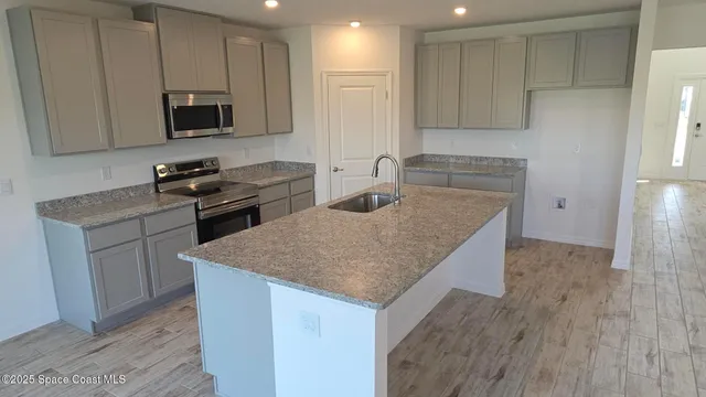 a kitchen with stainless steel appliances granite countertop a sink stove and microwave