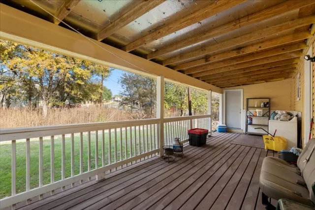 a view of a house with a yard and a wooden deck