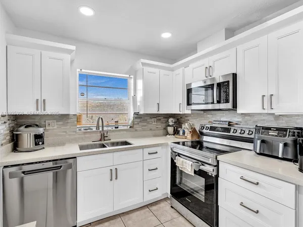 a kitchen with appliances a sink and cabinets