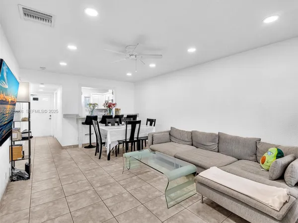 a living room with furniture and kitchen view