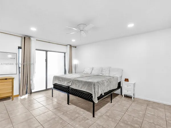 a spacious bedroom with a bed and a chandelier