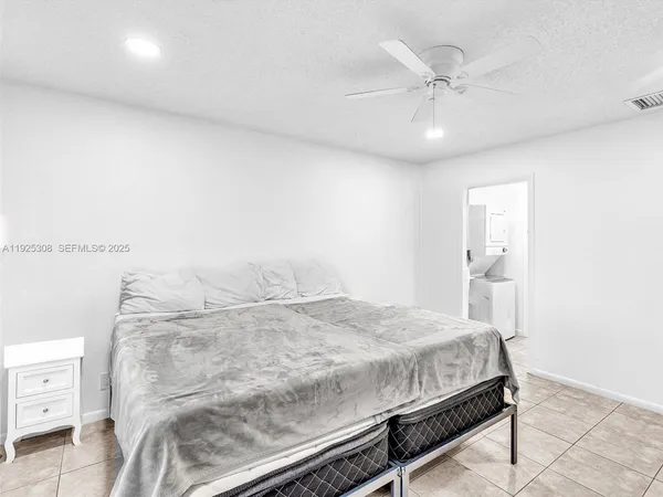 a bedroom with a bed and a ceiling fan