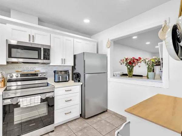 a kitchen with stainless steel appliances white cabinets and a refrigerator