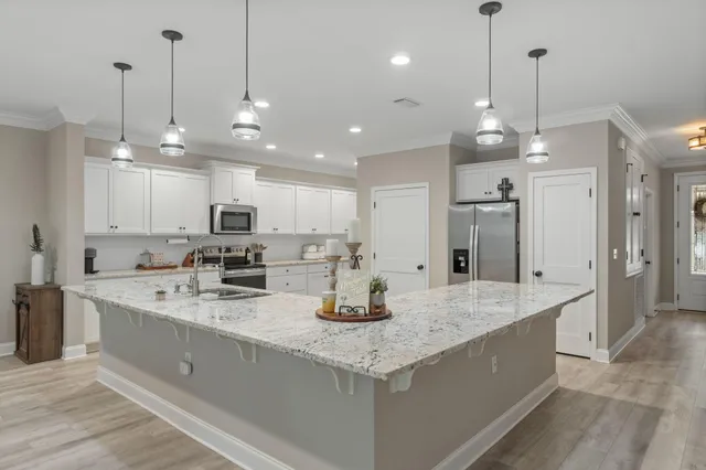 a kitchen with stainless steel appliances granite countertop a sink a center island and cabinets