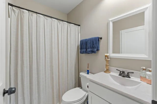 a bathroom with a sink vanity mirror and toilet