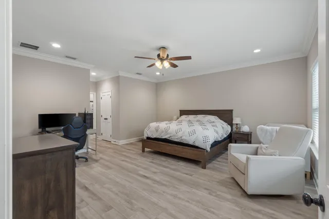 a bedroom with a bed couch and a chandelier