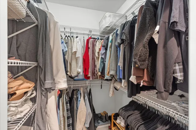 a view of walk in closet with clothes