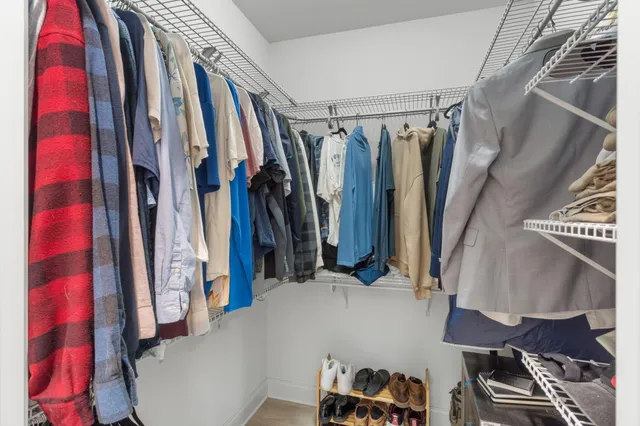 a view of walk in closet with clothes and shoes