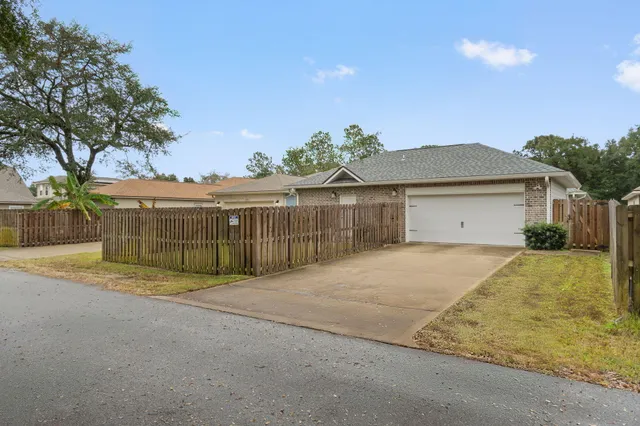 a view of a house with a backyard and a tree
