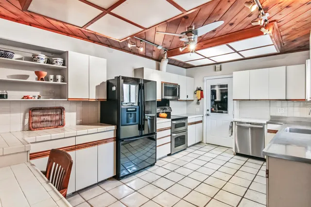 a kitchen that has a lot of cabinets in it and appliances