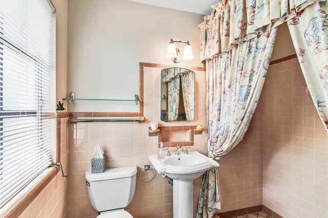 a bathroom with a sink and mirror with bathtub