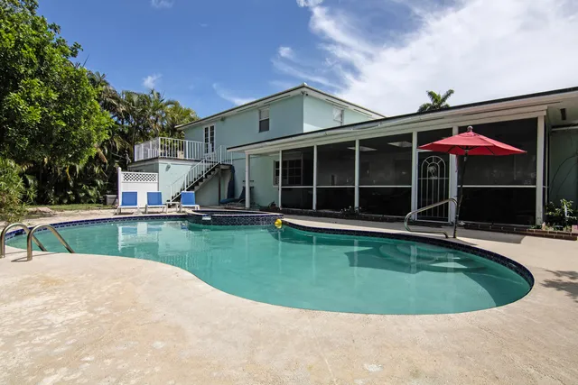 a view of a house with a swimming pool and a yard