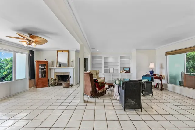 a living room with furniture a fireplace and potted plants with the potted plants