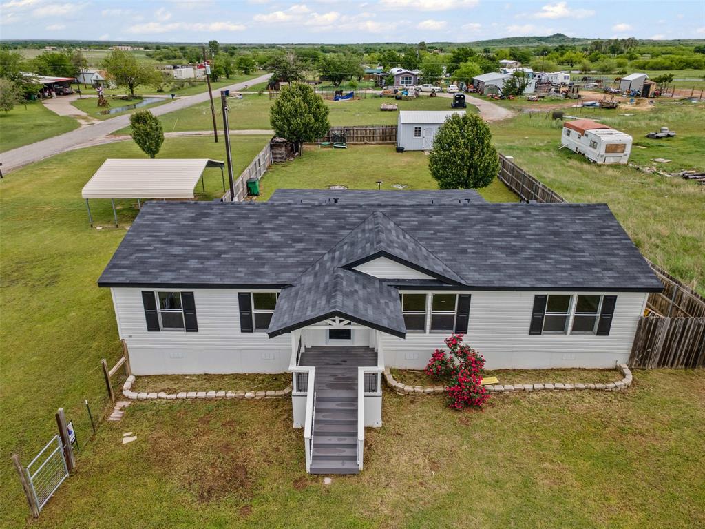 an aerial view of a house with a garden and lake view