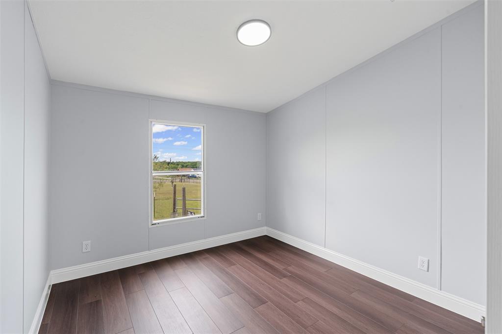 430 Indian Hills Road Bowie, TX 76230 - Photo 13 of 36 an empty room with wooden floor and windows