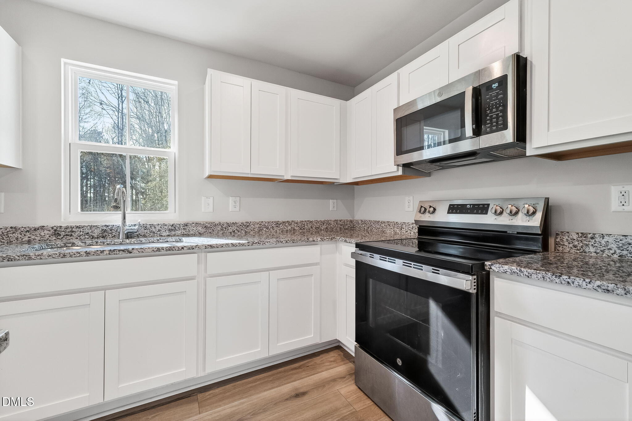 6684 Gibraltar Rock Drive Raleigh, NC 27610 - Photo 12 of 33 a kitchen with granite countertop white cabinets stainless steel appliances and a sink