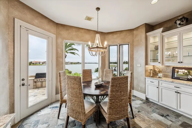 a dining room with furniture a chandelier and wooden floor