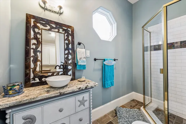 a bathroom with a granite countertop sink and a mirror
