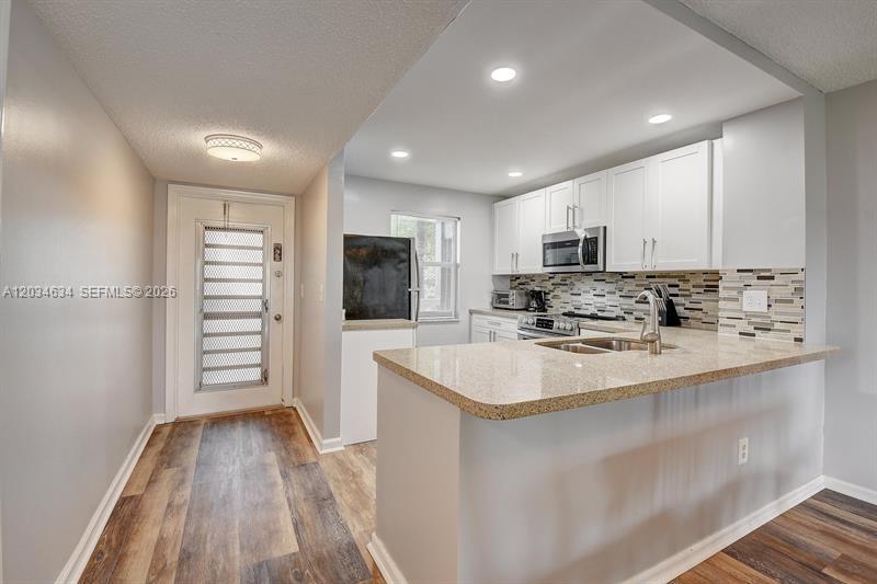 9880 Marina Boulevard, Unit 1516 Boca Raton, FL 33428 - Photo 5 of 32 a large kitchen with stainless steel appliances granite countertop a sink and dishwasher a stove with wooden floor