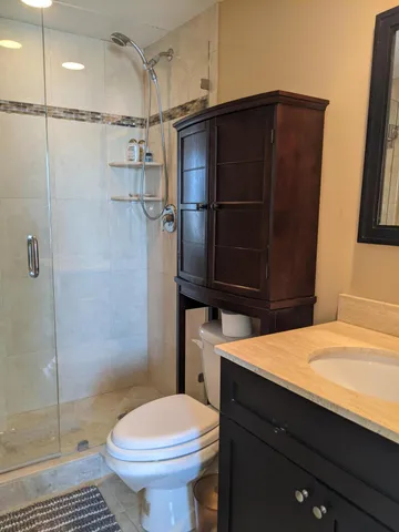 a bathroom with a sink a toilet and shower