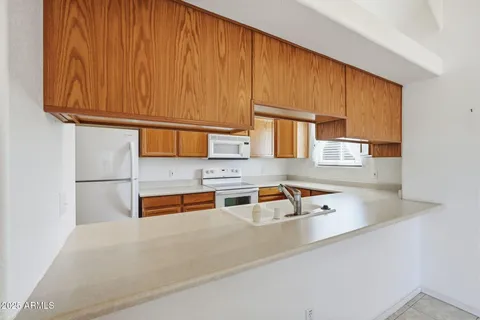 a kitchen with stainless steel appliances granite countertop a sink a stove a microwave oven cabinets and a counter top space