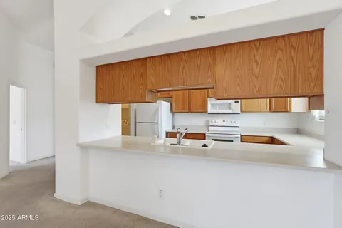 a kitchen with stainless steel appliances granite countertop a sink a stove and a microwave with cabinets