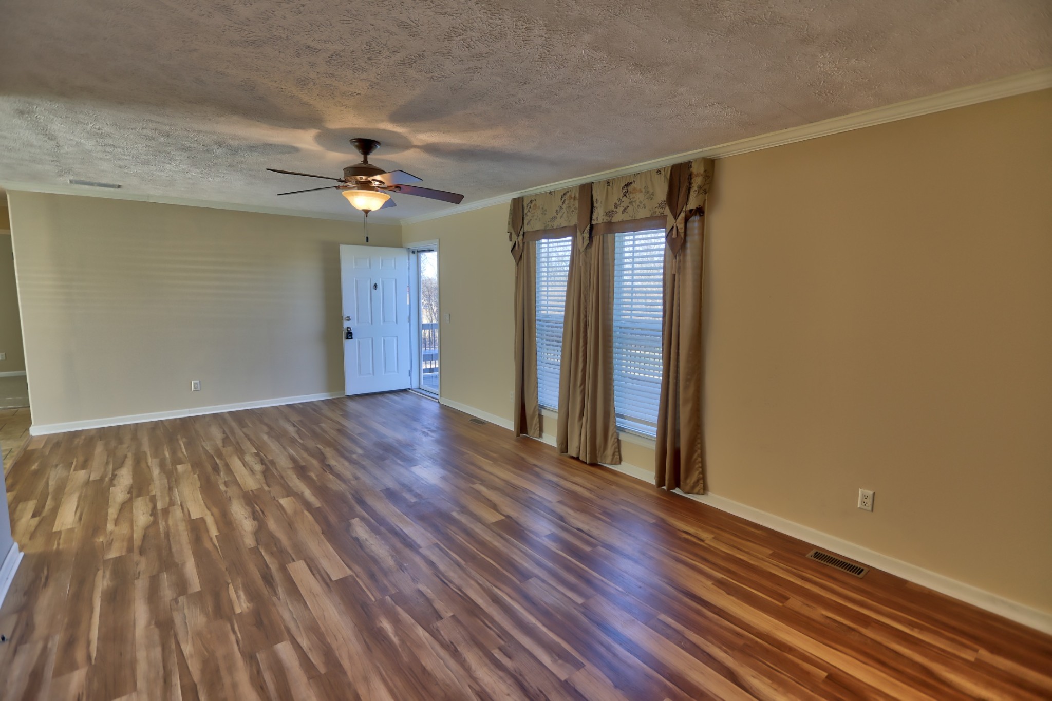 7438 Chowning Road Springfield, TN 37172 - Photo 16 of 33 a view of an empty room with wooden floor and a ceiling fan