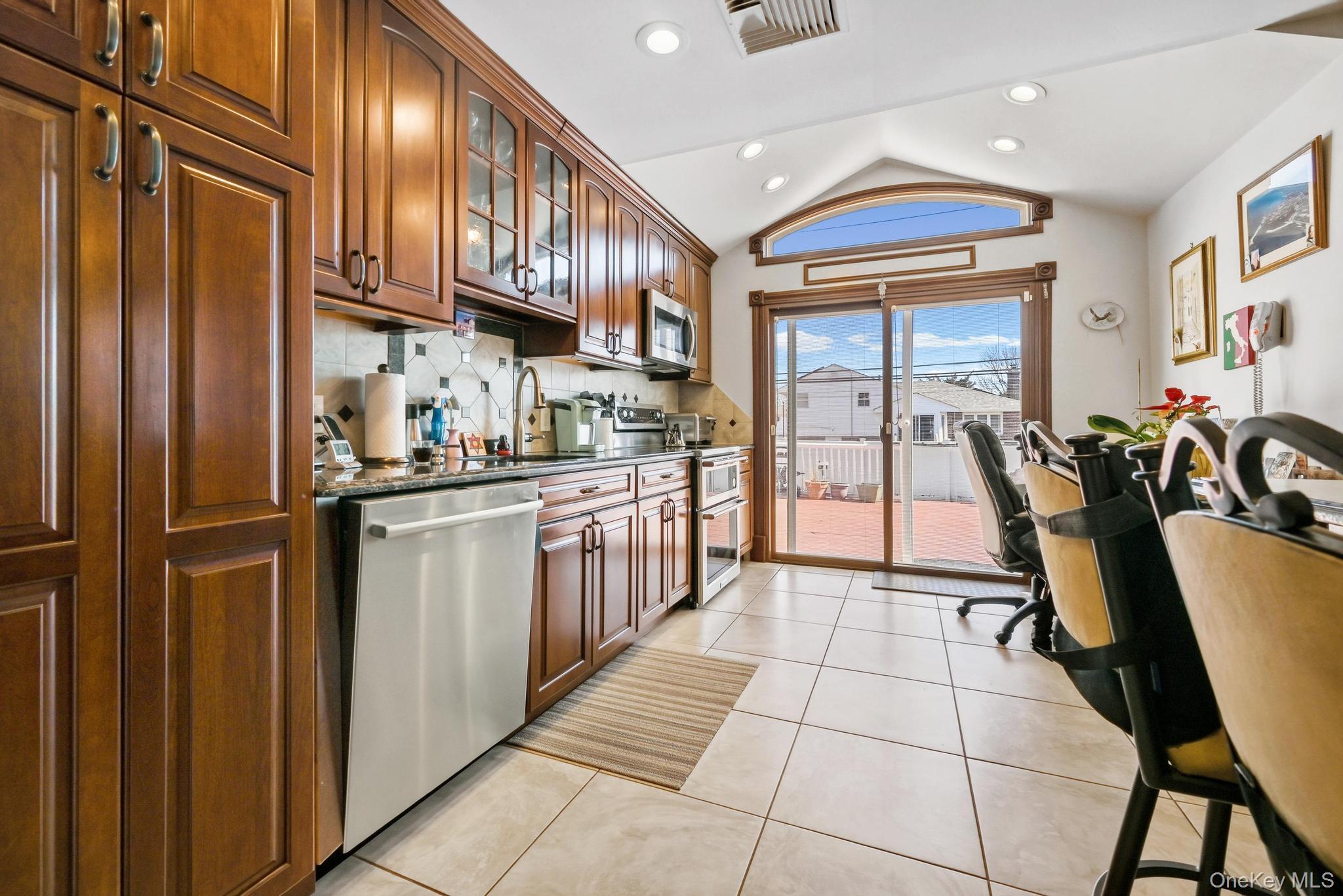3 Chapin Road Farmingdale, NY 11735 - Photo 13 of 26 a kitchen with stainless steel appliances granite countertop a refrigerator a sink dishwasher and a black cabinets next to a window