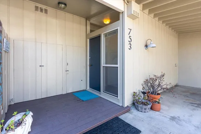 a living room with furniture a flat screen tv and a floor to ceiling window