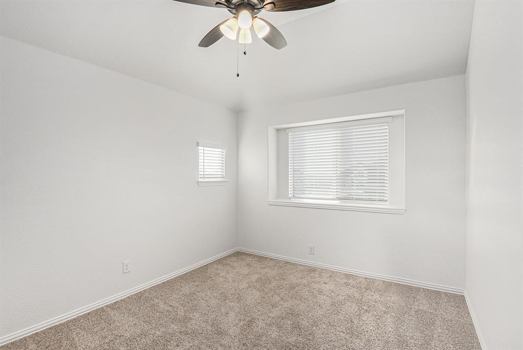 303 Pineview Lane Ponder, TX 76259 - Photo 12 of 19 an empty room with a chandelier fan and windows