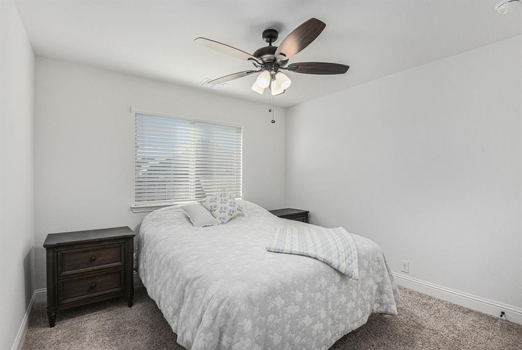 303 Pineview Lane Ponder, TX 76259 - Photo 9 of 19 a bedroom with a bed and a chandelier