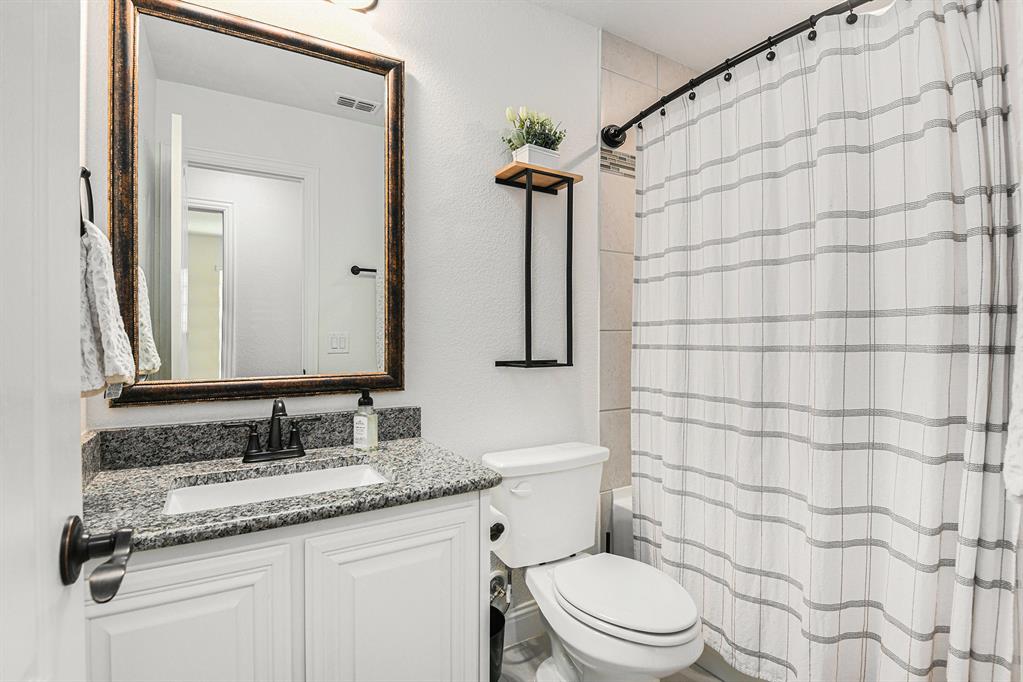 303 Pineview Lane Ponder, TX 76259 - Photo 10 of 19 a bathroom with a granite countertop toilet sink and mirror