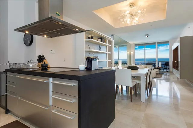 a dining hall with stainless steel appliances granite countertop a sink dishwasher a dining table and chairs with wooden floor